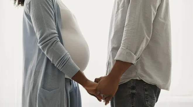 pregnant couple holding hands