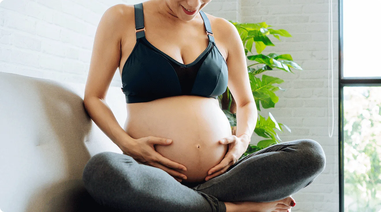 pregnant woman wearing a maternity bra at home
