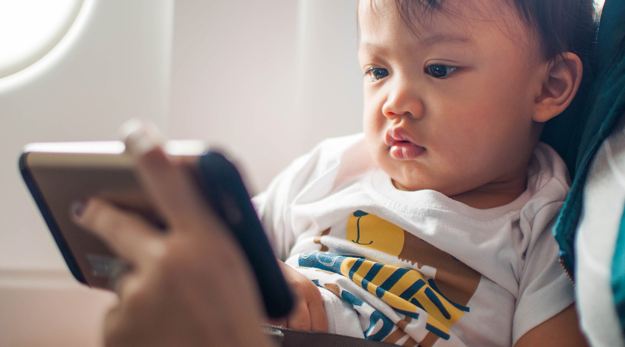 toddler watching screen while on a plane