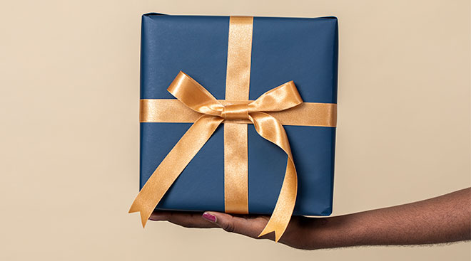 hand holding out beautifully wrapped gift