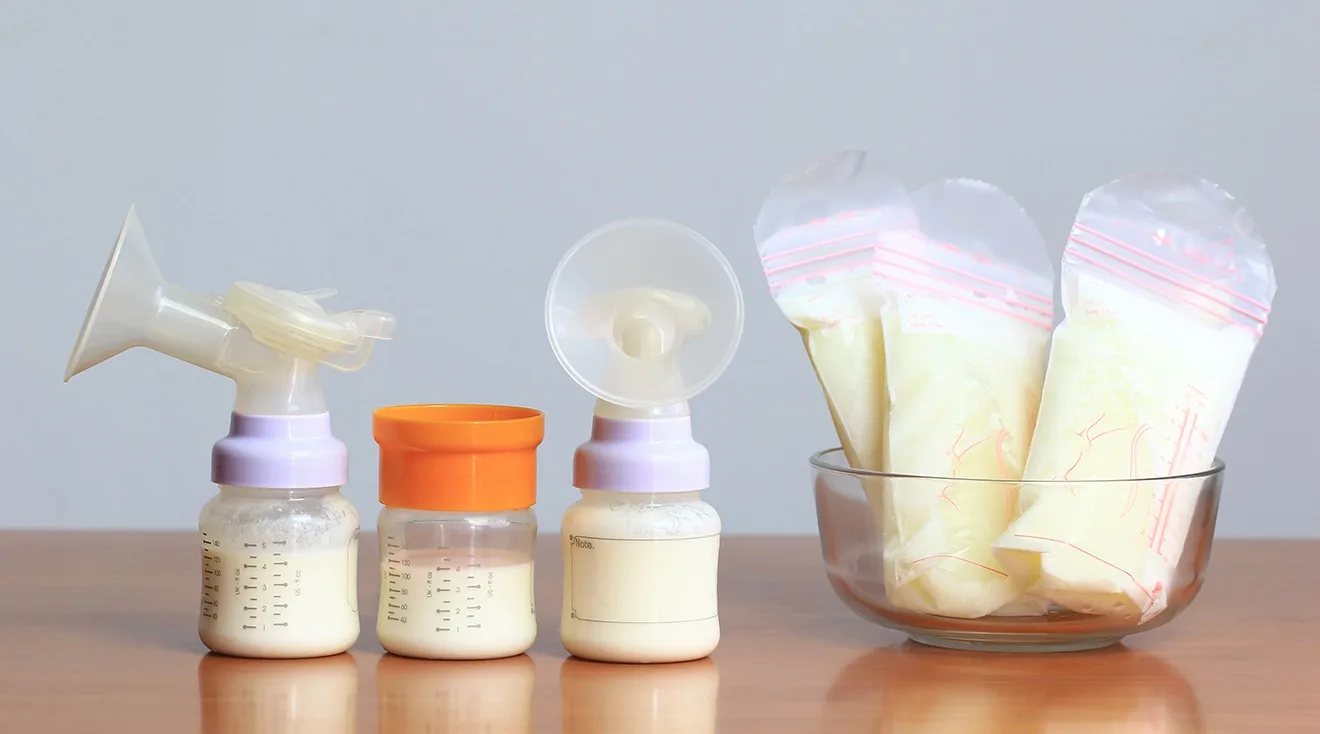 breast pump with bottles of breast milk and bags of frozen breast milk