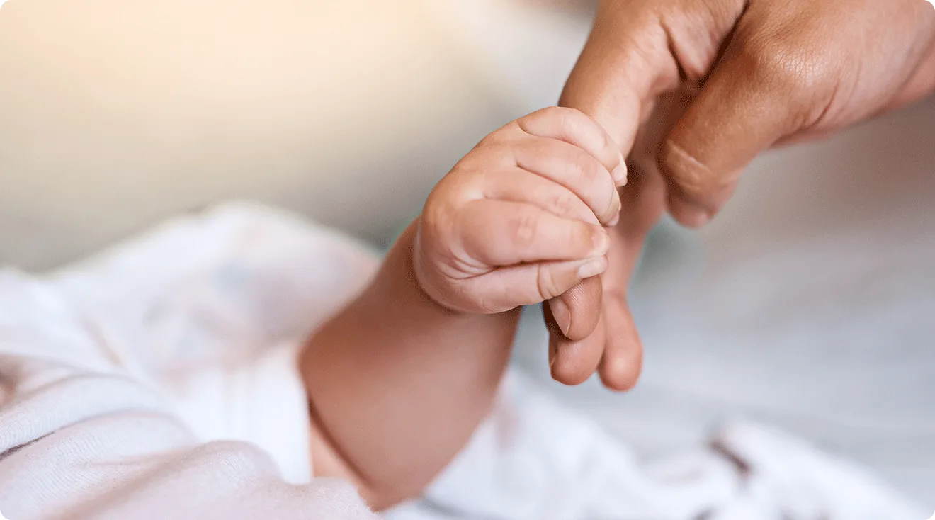 mom holding infant hand