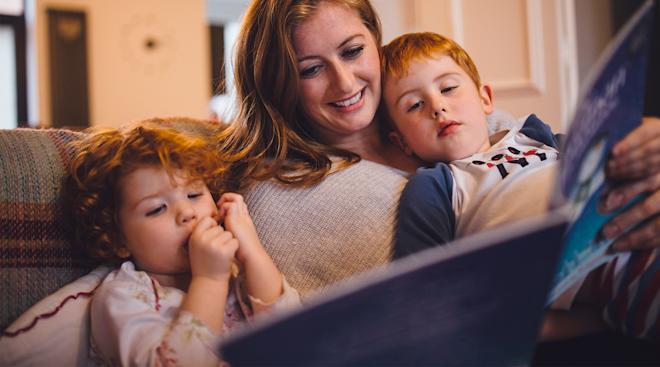 mom reading bedtime story to her young children