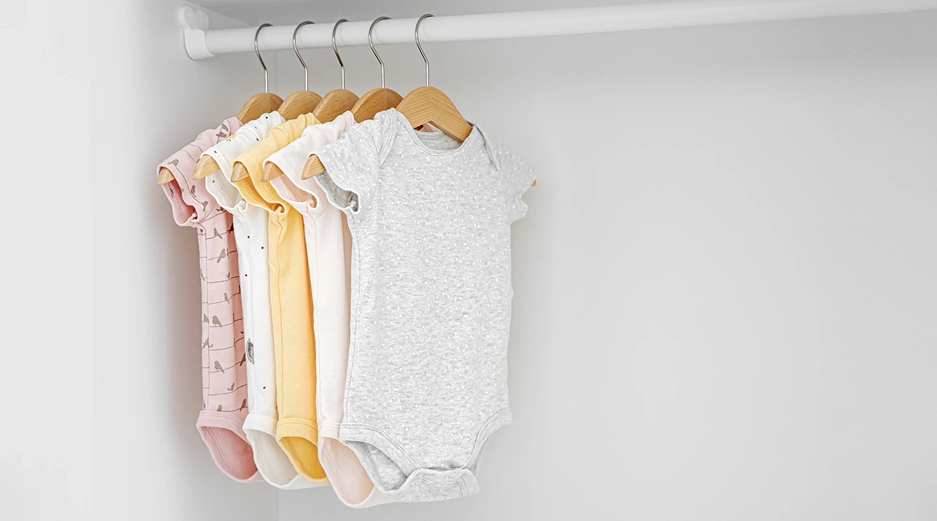 baby onesies hanging in closet