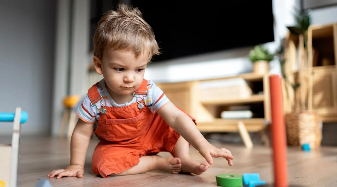 baby playing alone with toys on the floor