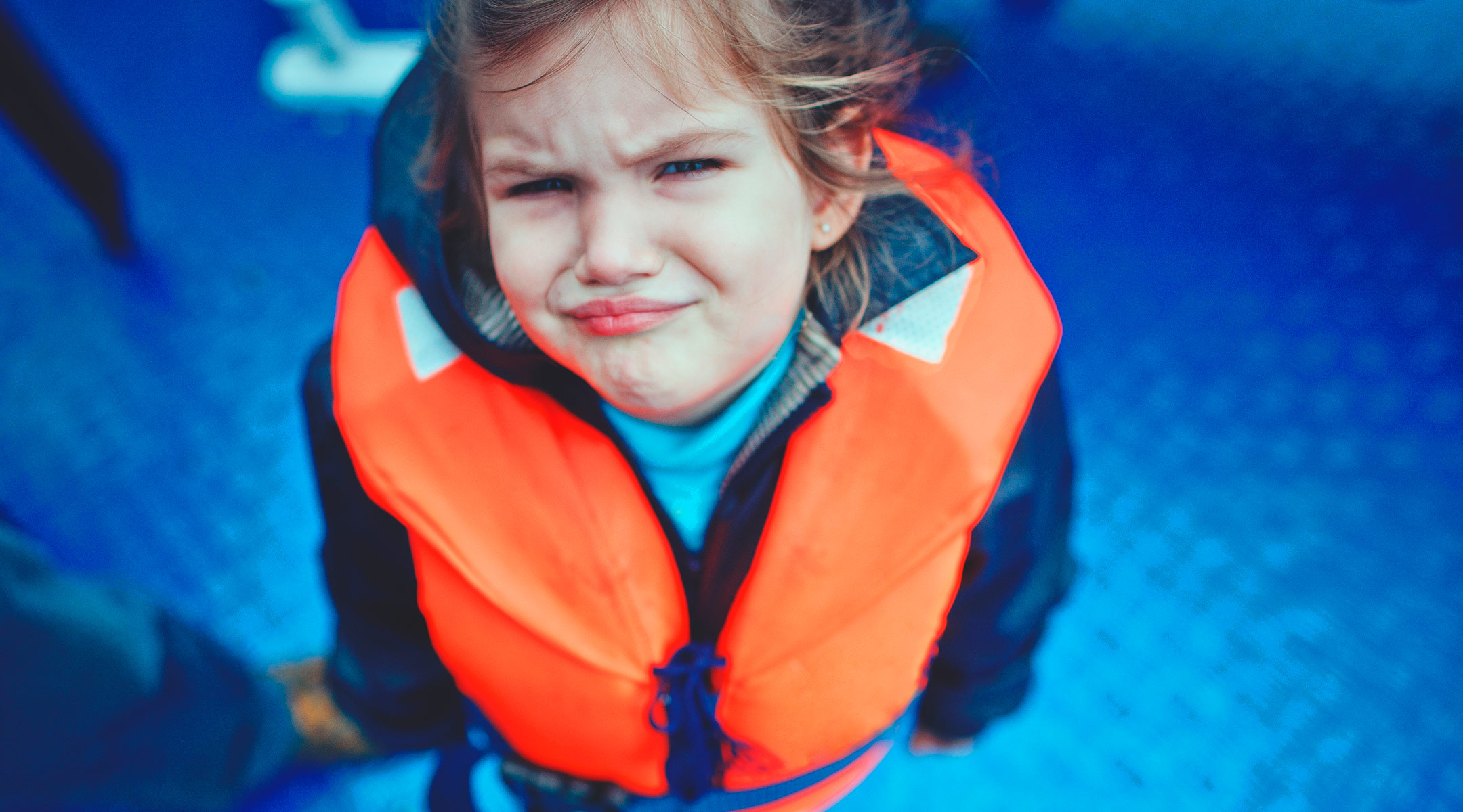 sad toddler wearing life vest
