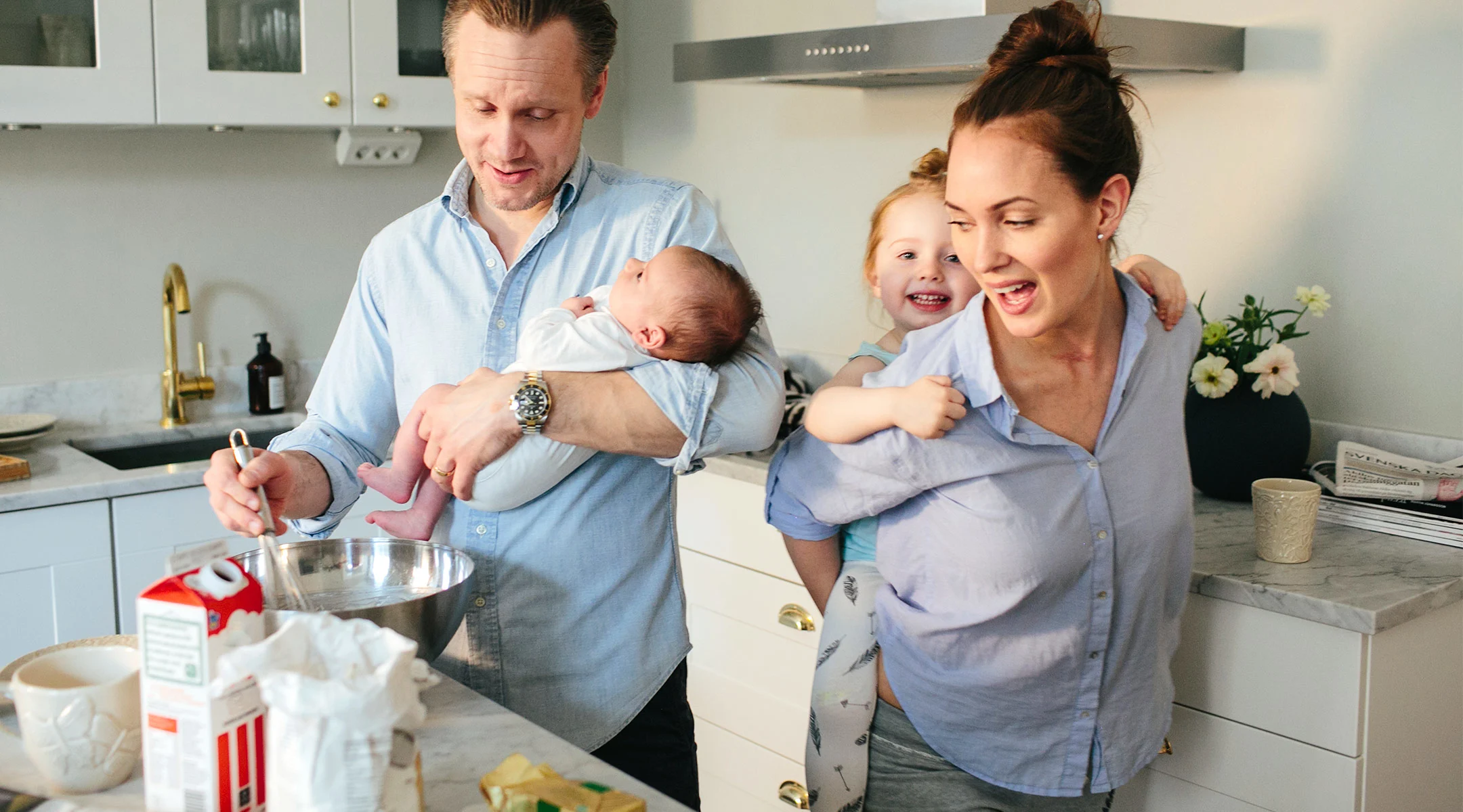parents entertain hyper children in their kitchen while cooking