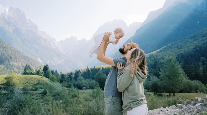 mother and father traveling with baby in the mountains
