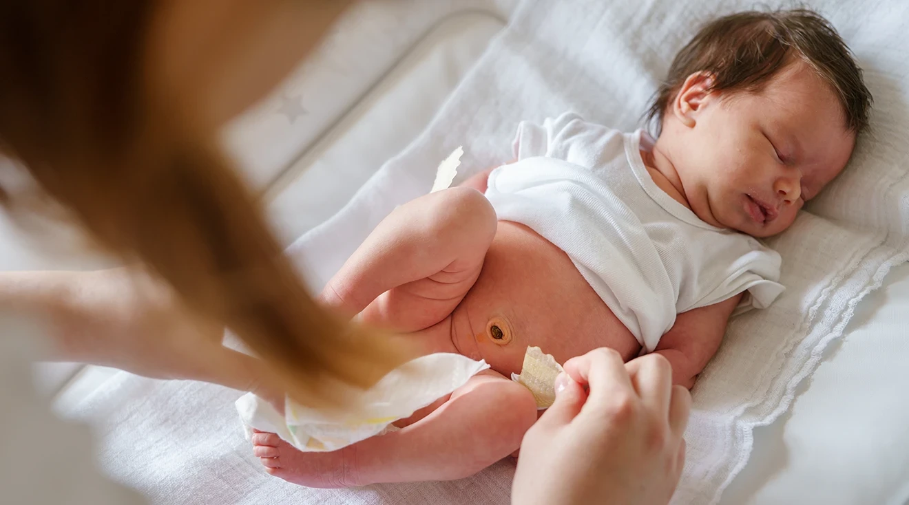 mother changing newborn baby's diaper
