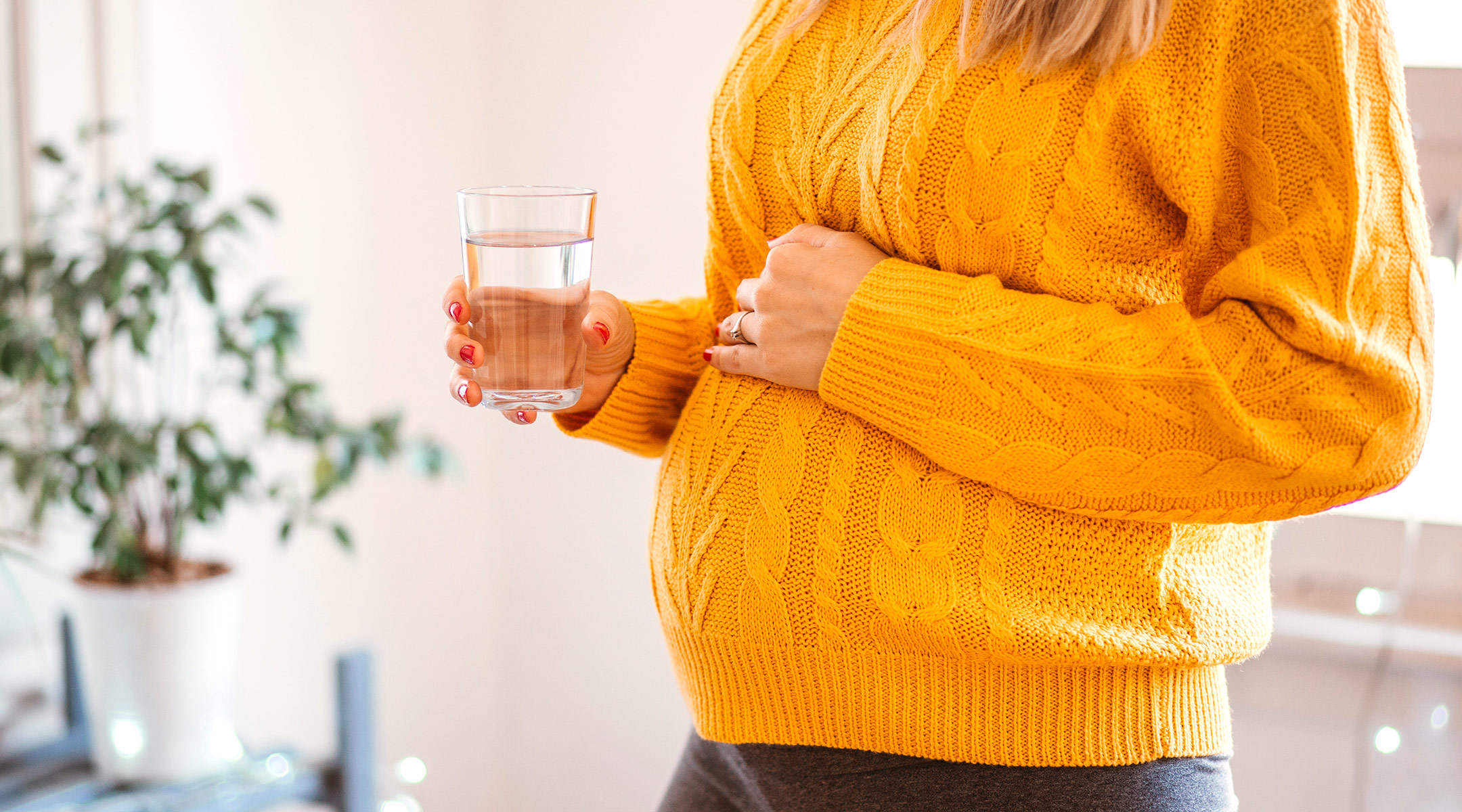 pregnant woman drinking glass of water