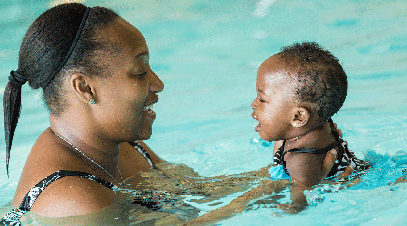 mom with baby in pool for swim lesson