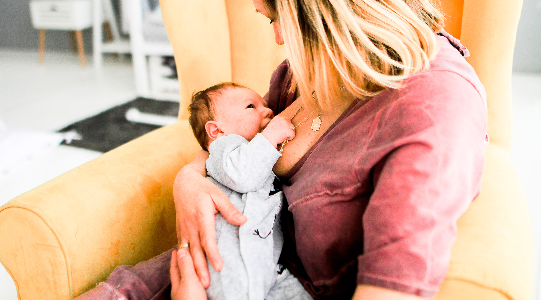 mom breastfeeding newborn baby at home