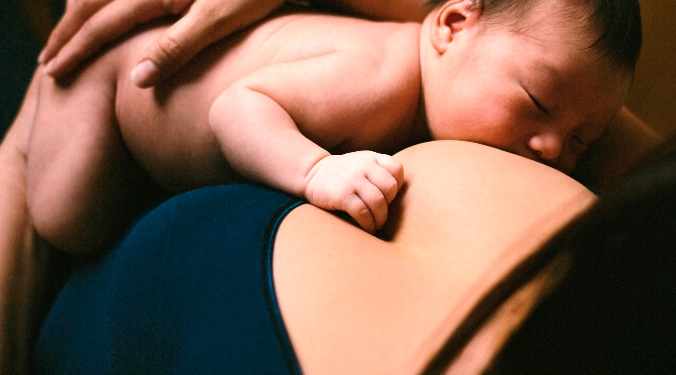 close-up of mom breastfeeding newborn baby