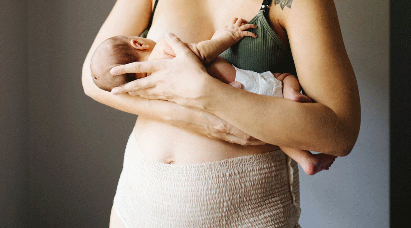 postpartum mother wearing a diaper while breastfeeding newborn baby