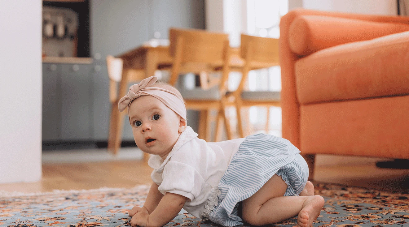 baby in crawling position on floor of home