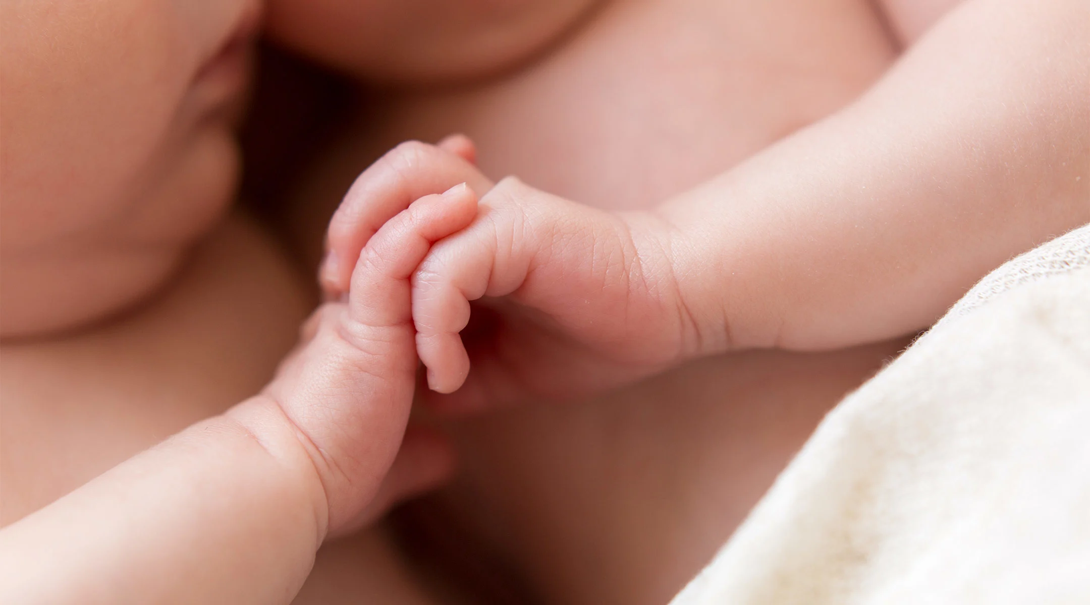 newborn twins ermbracing