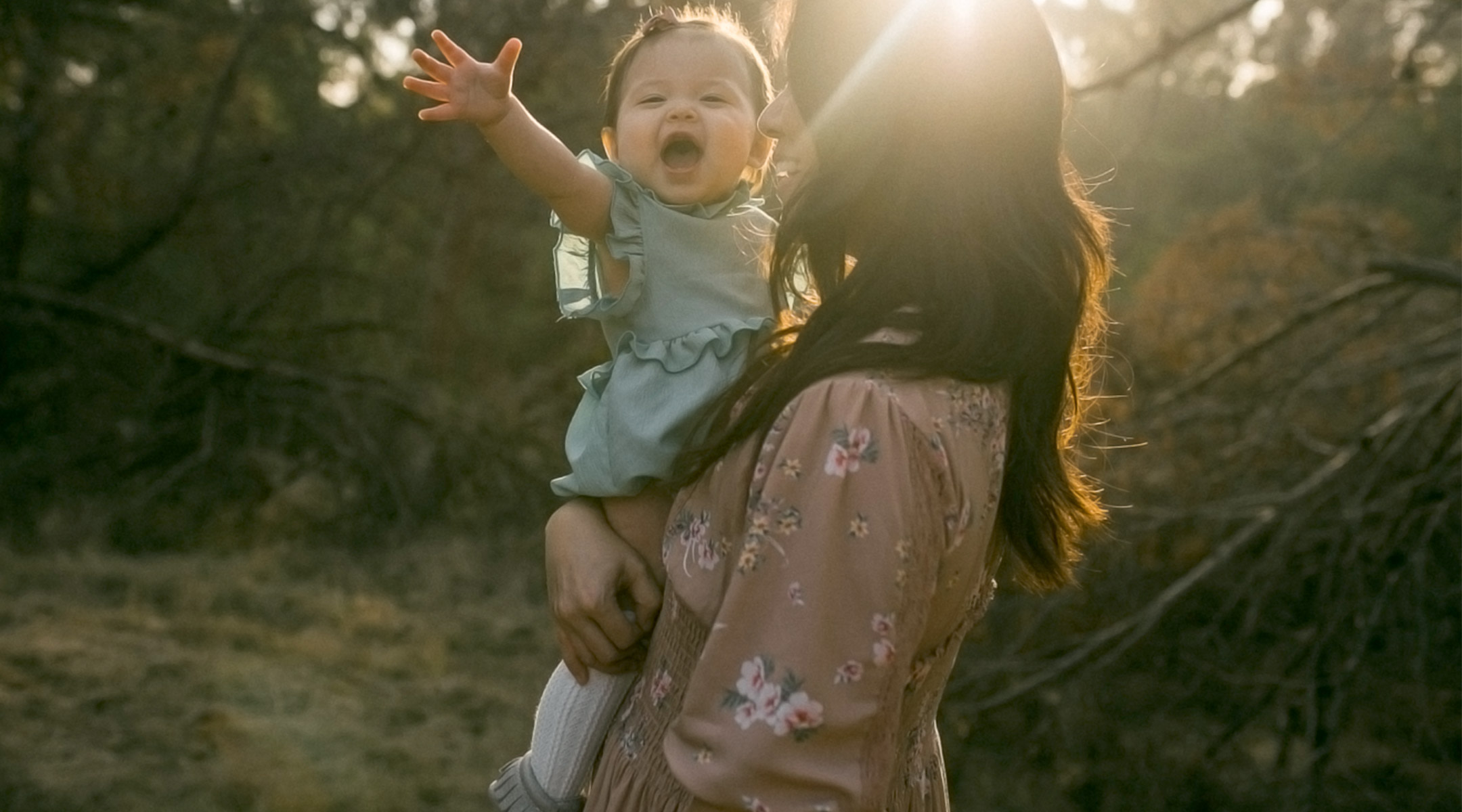 happy one year old girl held by her mom