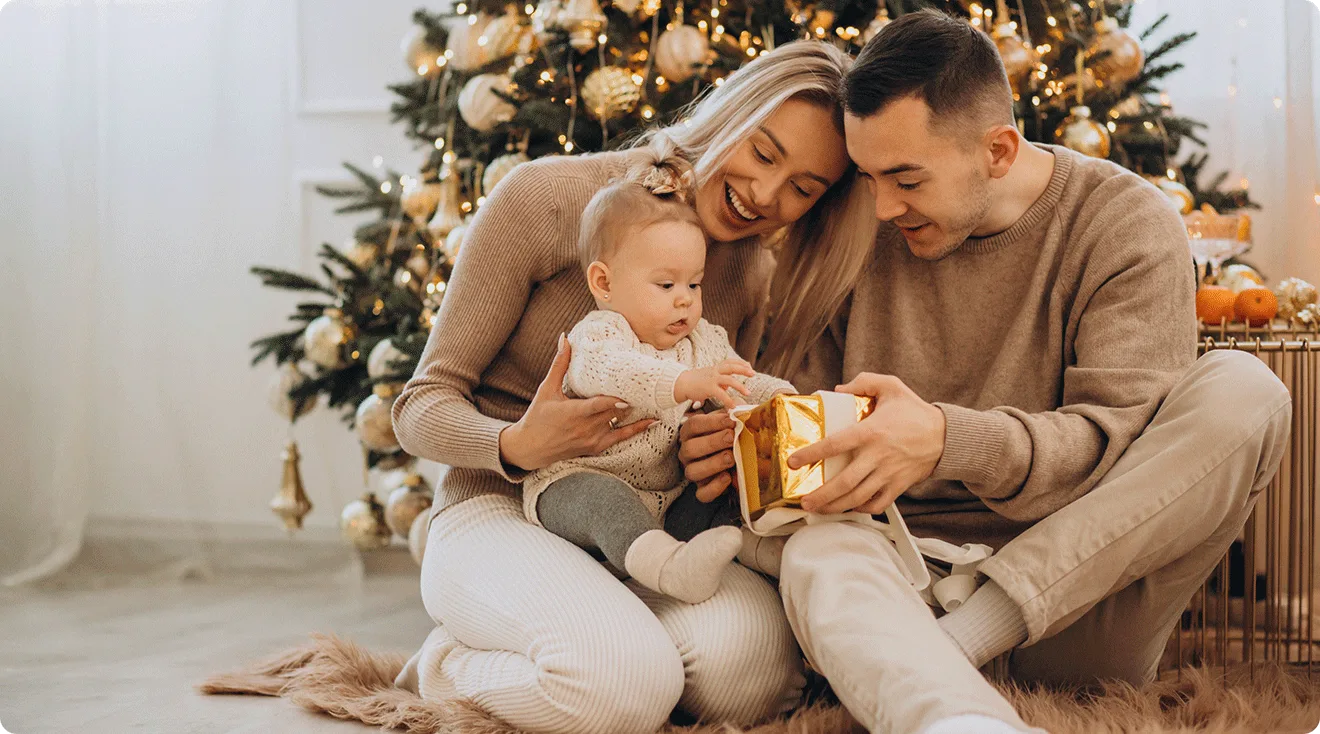parents giving baby a christmas gift