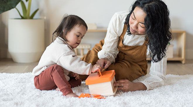 Child with special needs and her mom playing with montessori toys.
