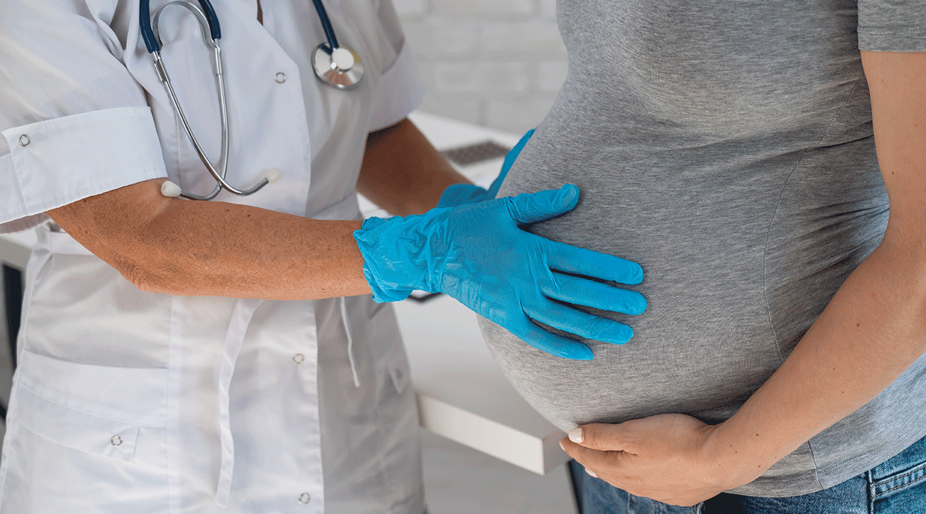 doctor examining pregnant woman's belly for membrane sweep