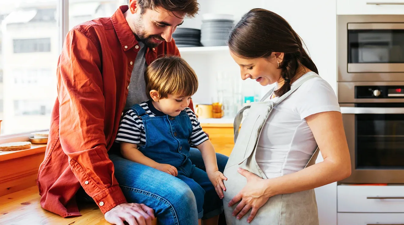 toddler pointing to pregnant mom's belly