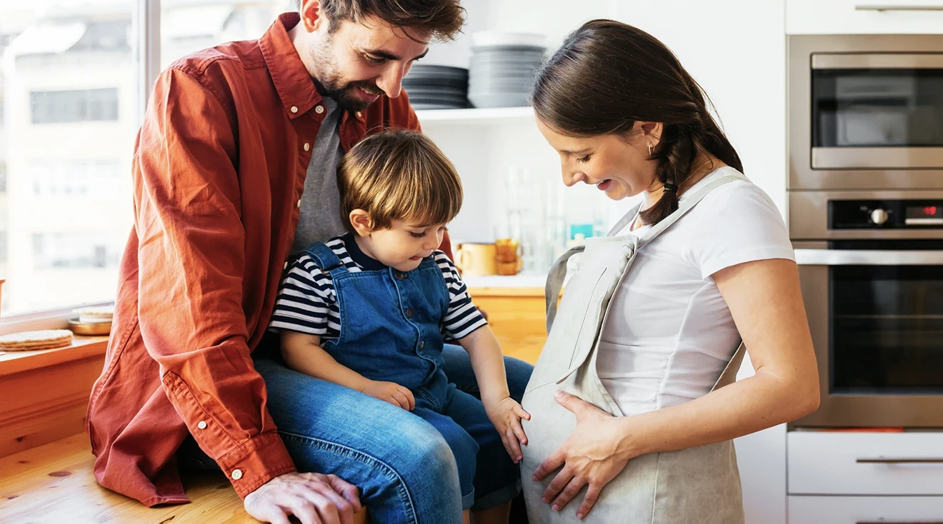 toddler pointing to pregnant mom's belly