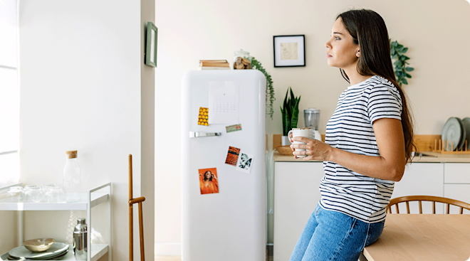 young woman standing waiting in kitchen at home