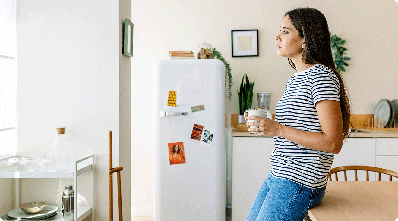 young woman standing waiting in kitchen at home