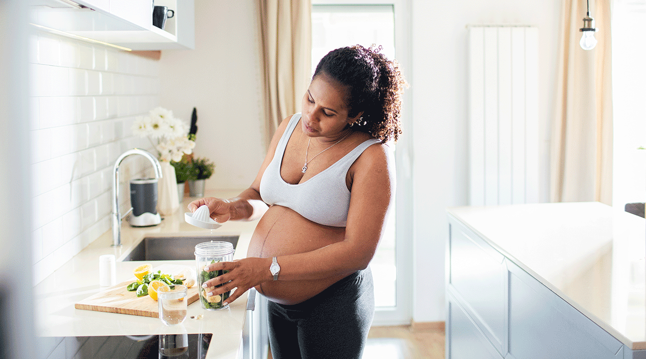 pregnant woman making healthy meal in kitchen at home