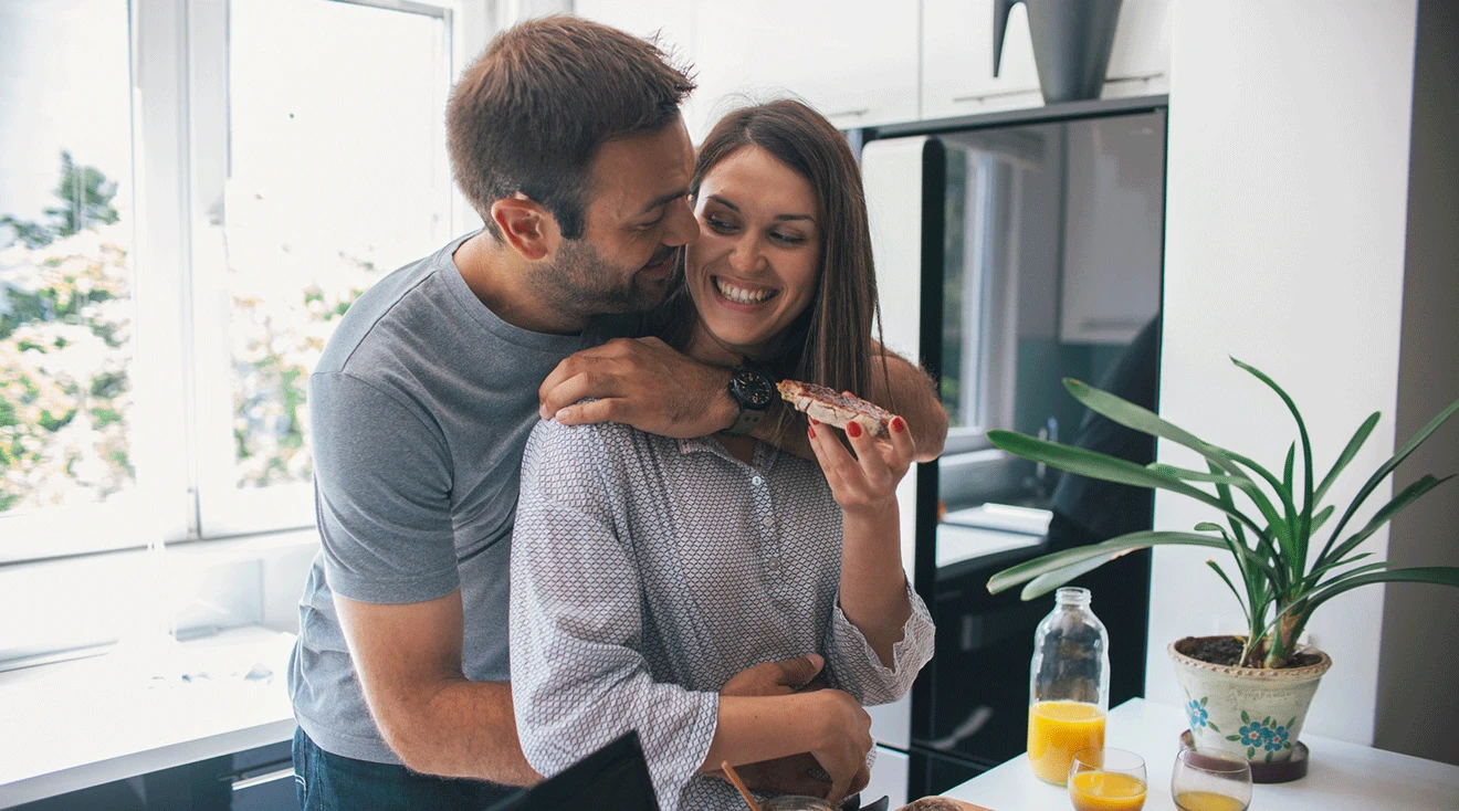 happy young couple eating breakfast at home