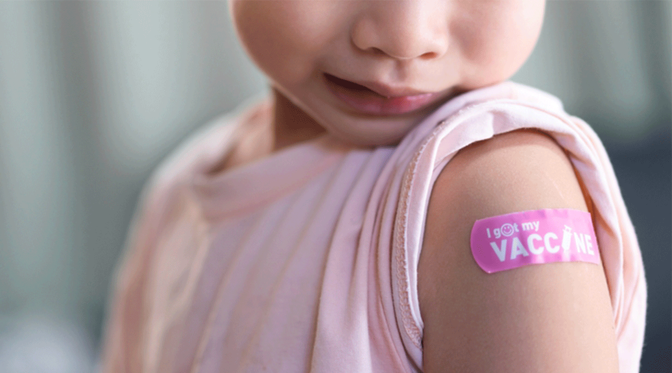 5 year old child with band aid on arm after getting a vaccine