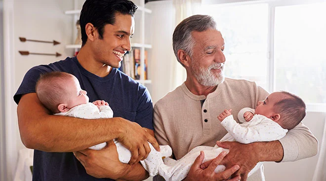 Three generations together in baby nursery, grandpa, dad and baby twins.