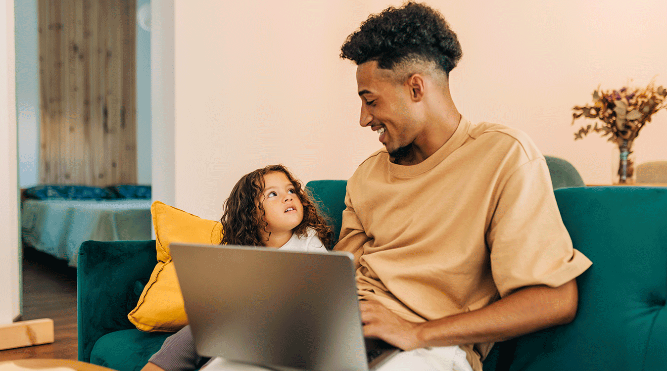 single dad sitting with daughter on the couch at home