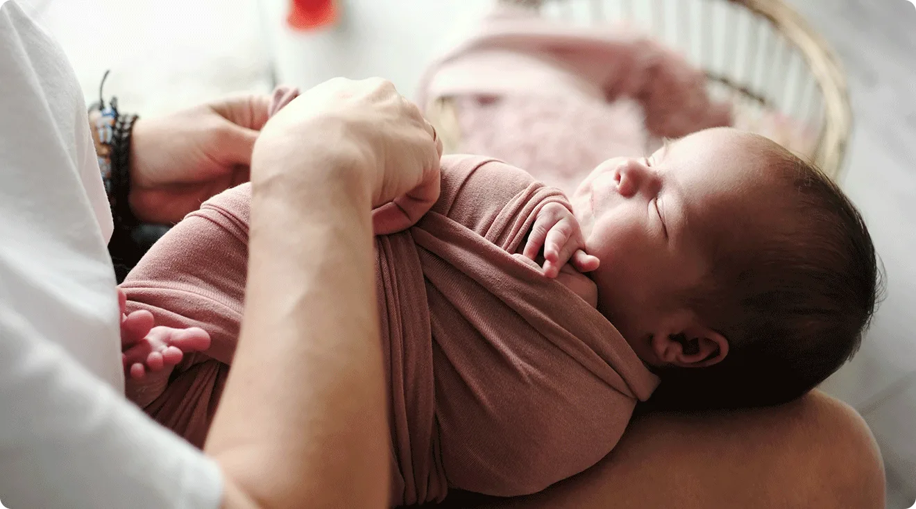 mom swaddling baby