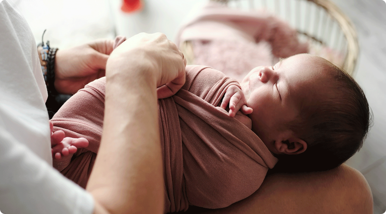 mom swaddling baby