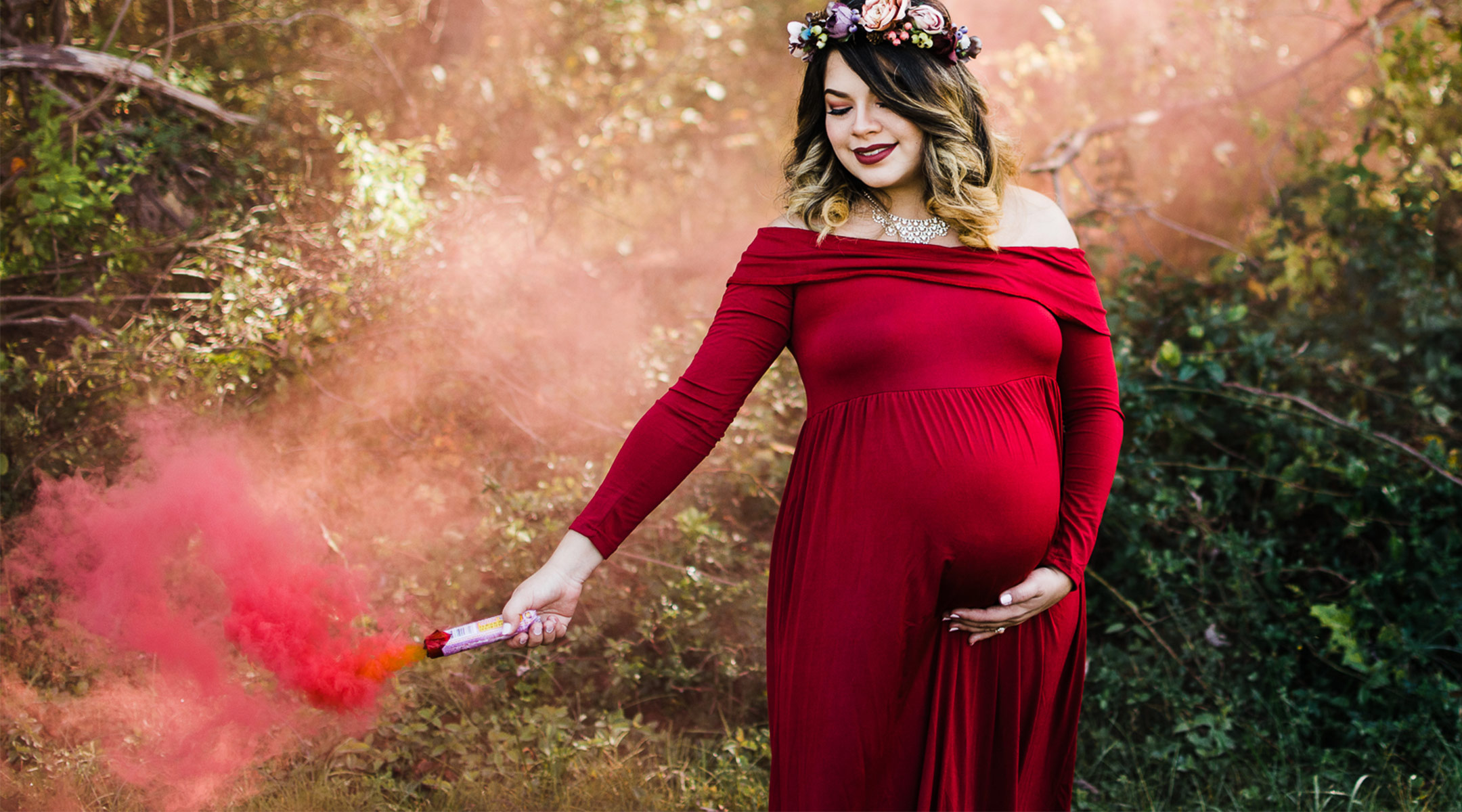 pregnant woman using pink smoke to reveal baby's gender