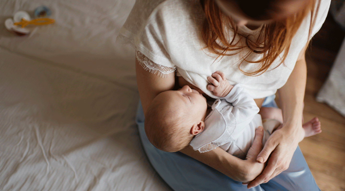 mother breastfeeding baby at home