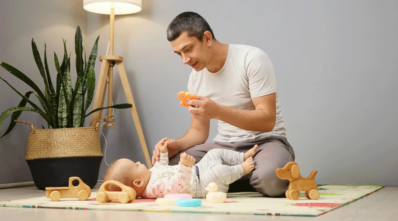 dad playing with baby at home with toys