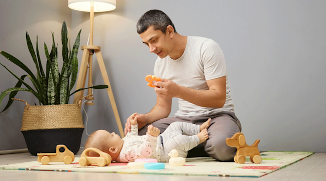 dad playing with baby at home with toys
