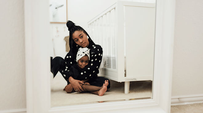 black mother and toddler looking into the mirror