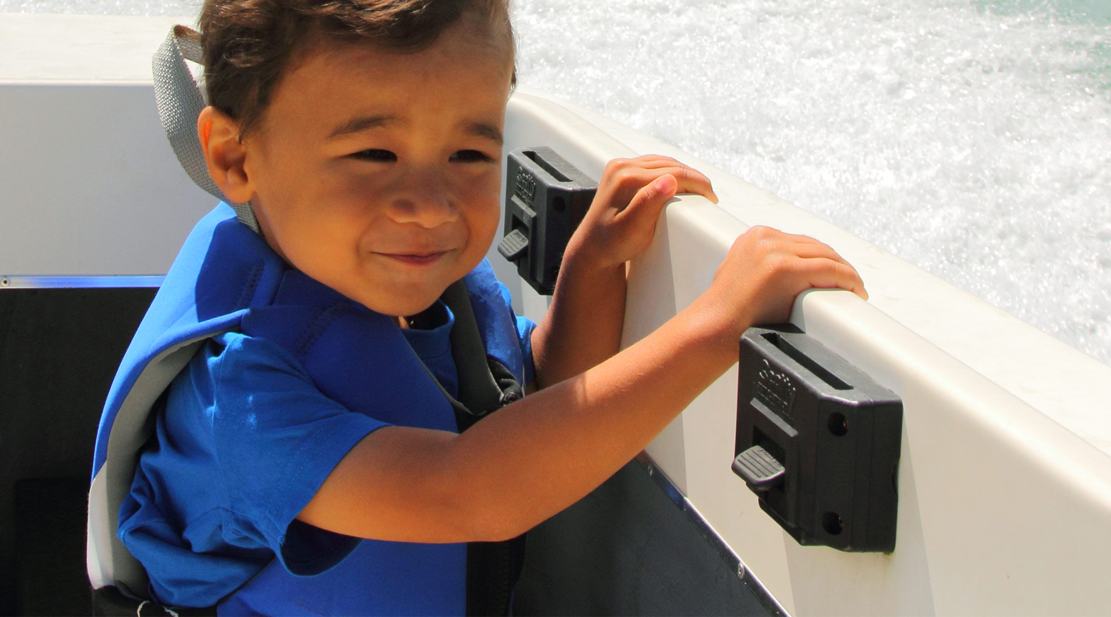 toddler boating on the open water and wearing a life vest