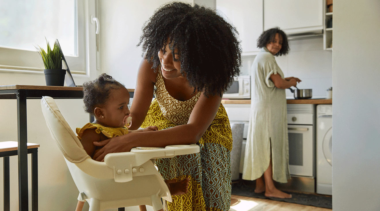 mom putting baby into high chair