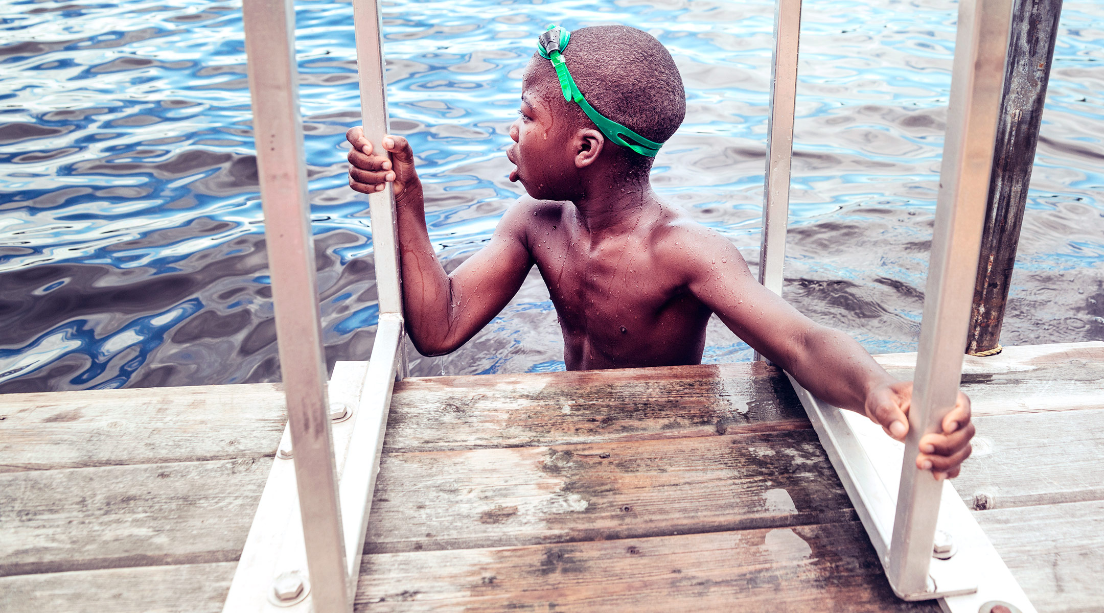 boy by dock, swimming in water