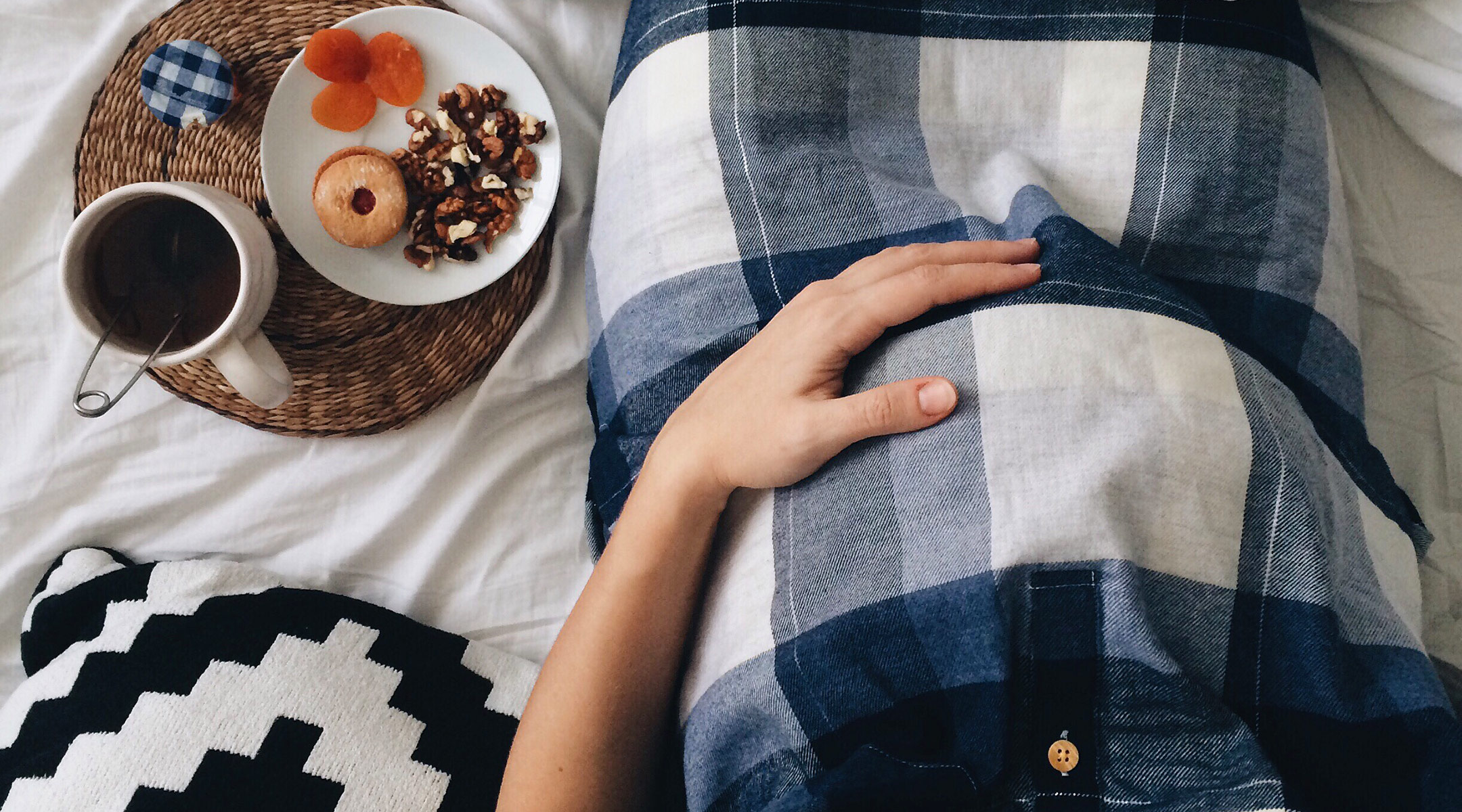 pregnant woman in bed with plate of food