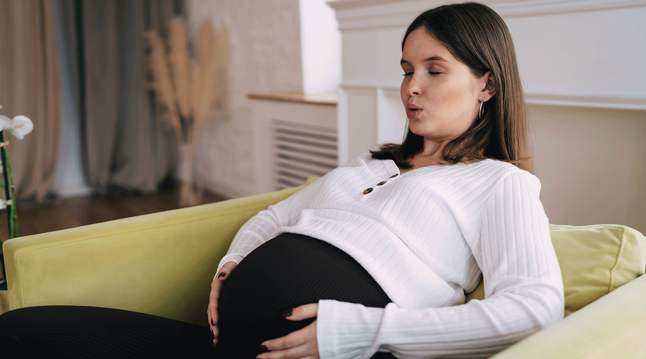 pregnant woman deep breathing on couch at home