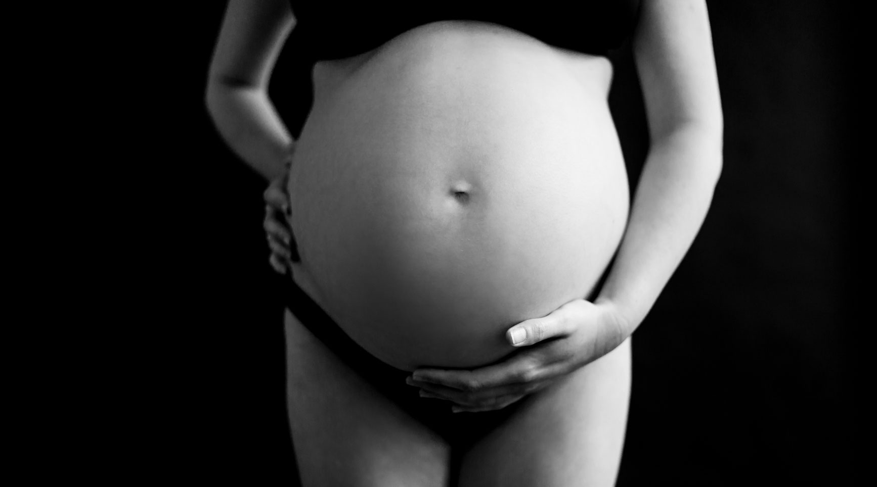 pregnant woman poses for black and white photo