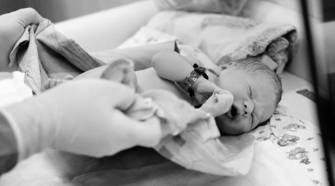 newborn baby and nurse in hospital after delivery 