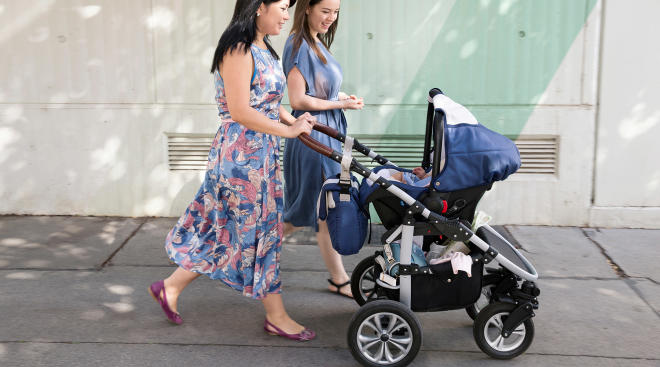 women friends pushing stroller outside together