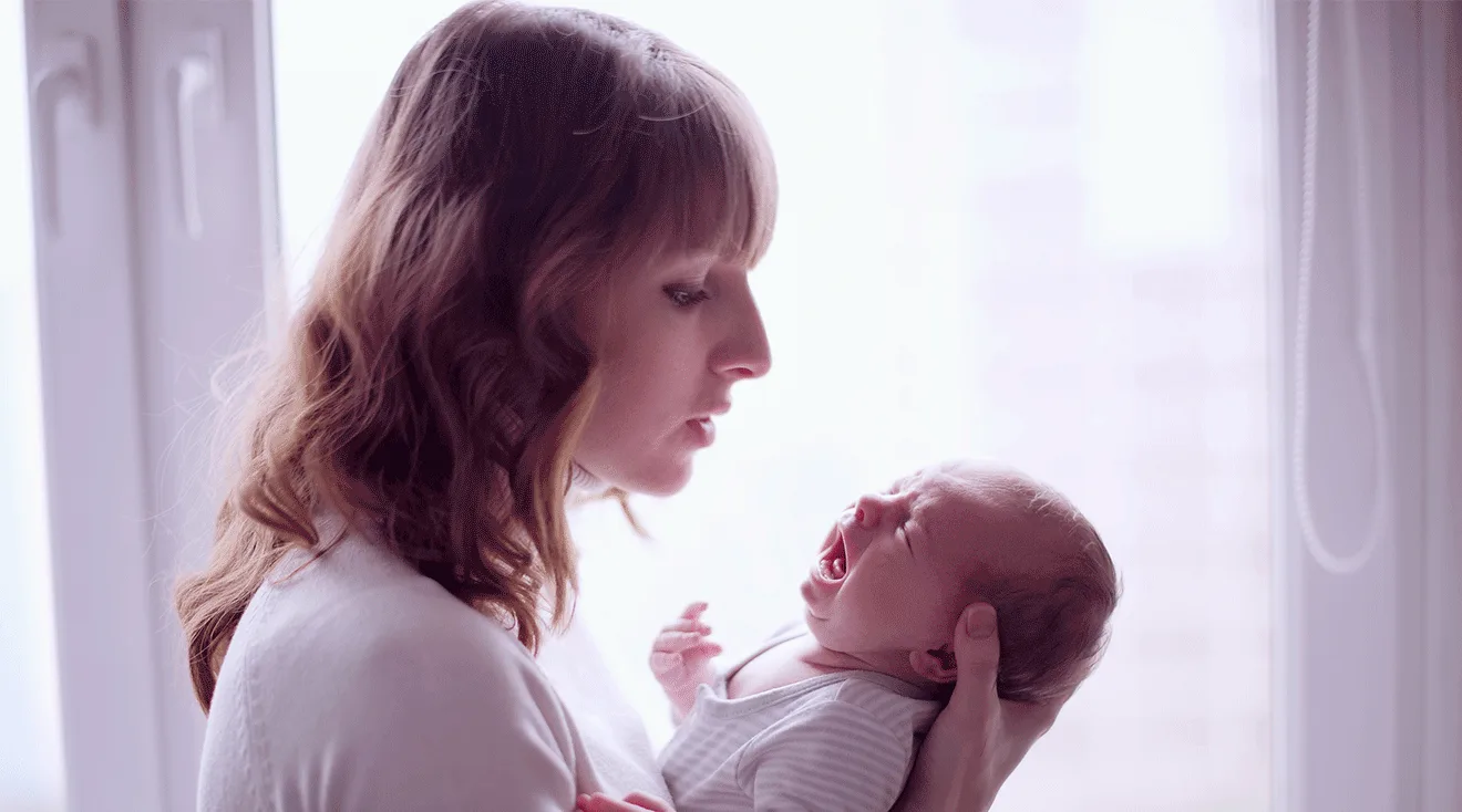 mother holding crying newborn baby