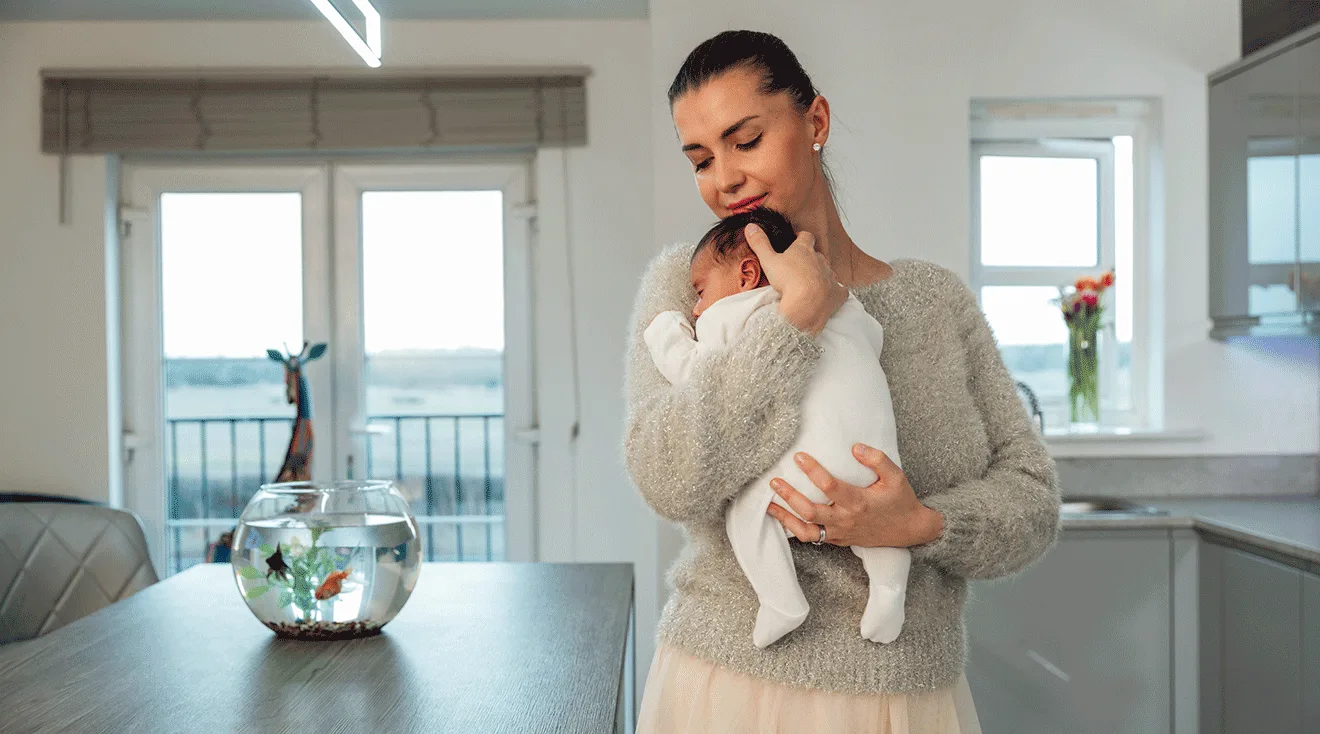 mom holding newborn baby at home